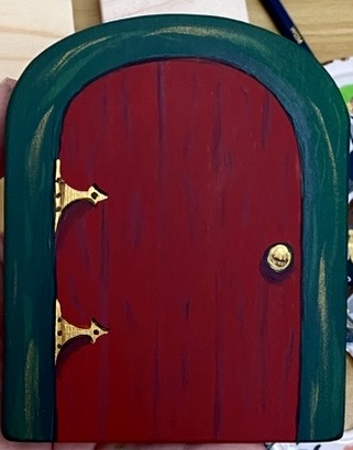 Close-up of a finished hand-painted maple Julenissen door with brass hinges